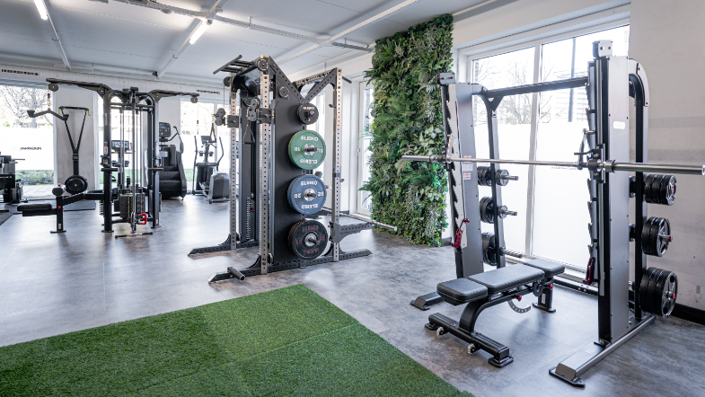 Jesse Meijer Personal Training Kunstgras en rek met gewichten in de gym